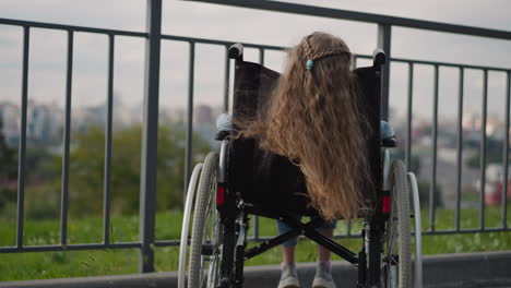 Long-ginger-hair-of-little-girl-in-wheelchair-waves-in-wind