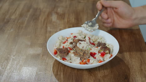 Man-eats-rice-with-meat-and-fresh-vegetables-using-spoon