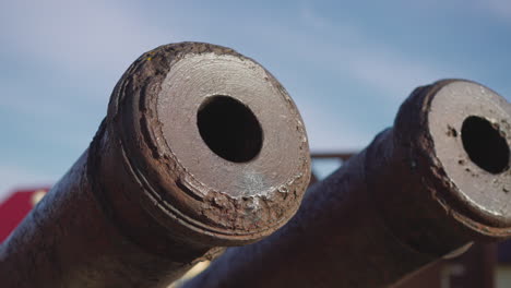 Cannon-tubes-and-muzzles-covered-with-rust-against-blue-sky
