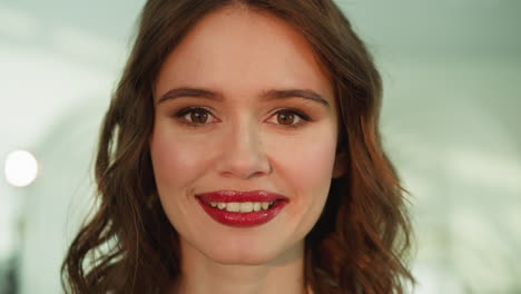 Happy-woman-with-bright-lip-gloss-looks-in-camera-smiling