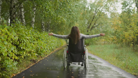 Woman-with-spinal-cord-injury-stretches-arms-enjoying-walk