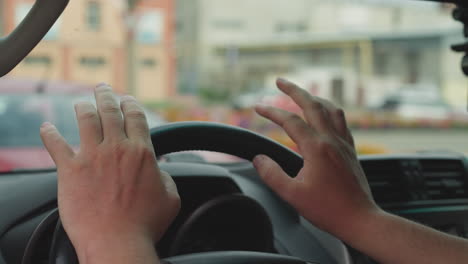 Impatient-man-taps-fingers-on-steering-wheel-sitting-in-car