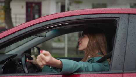 Cheerful-woman-smiles-stretching-hand-out-of-car-window