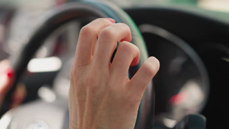 Female-hands-with-red-manicure-hold-steering-wheel-of-car