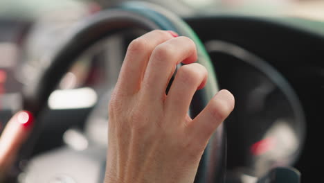 Lady-driver-holds-steering-wheel-tapping-fingers-expectantly