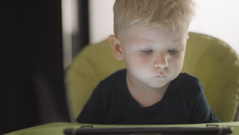 Ruhiger-Kleinkindjunge-Schaut-Sich-Zeichentrickfilme-über-Den-Tablet-Computer-An