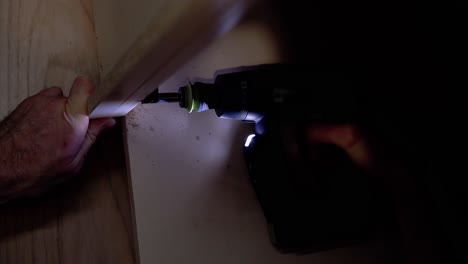 Screwing-the-screw-into-the-table-surface-with-a-screwdriver-5-Screwdriver-highlights-the-place-of-twisting-Close-up
