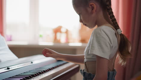 Diligent-girl-plays-electronic-piano-with-right-hand