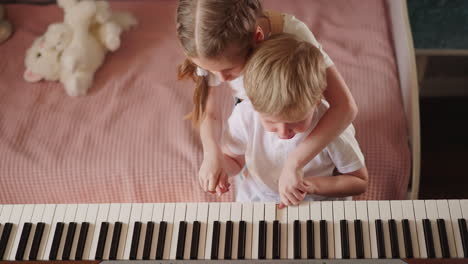 Blonde-little-girl-presses-piano-keys-with-crying-brother