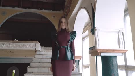 young-pretty-girl-dressed-in-leather-wings-and-a-leather-skirt-descends-the-stairs-in-an-abandoned-building