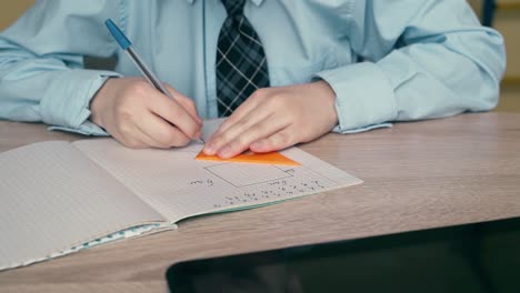 Ext-Cu-Tracking-Schüler-Macht-Hausaufgaben-Schreibt-Stift-In-Ein-Notizbuch-Verwendet-Dreieckiges-Lineal-Auf-Dem-Tisch-Ist-Tablet