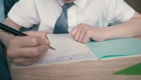 Schoolchildren-do-homework-write-numbers-in-notebook-helping-each-other