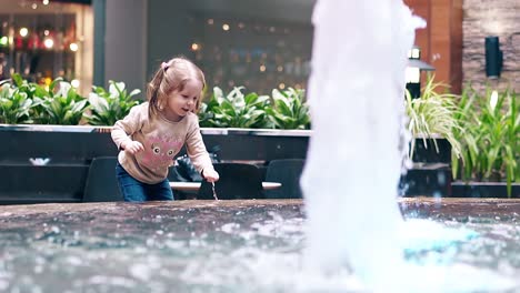 Slow-motion-Little-sweet-girl-playing-with-water-near-fountain-1
