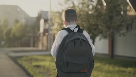 CU-Tracking-Back-view-Portrait-of-schoolboy-with-knapsack-behind-his-back-in-school-uniform