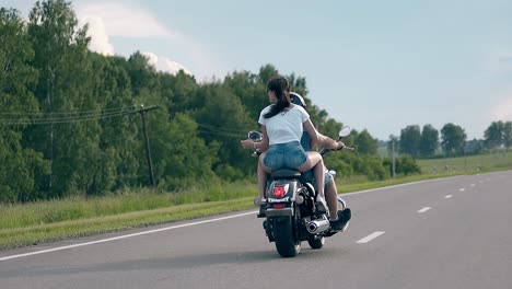Junge-Frau-Fährt-Mit-Schwarzem-Motorrad-An-Bäumen-Vorbei