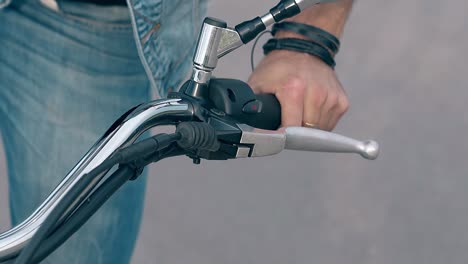 closeup-man-sits-on-motorcycle-holding-black-handlebar