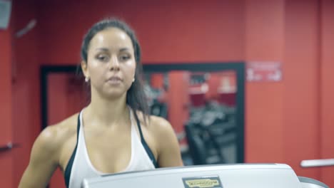 close-view-pretty-young-woman-runs-on-treadmill-in-gym