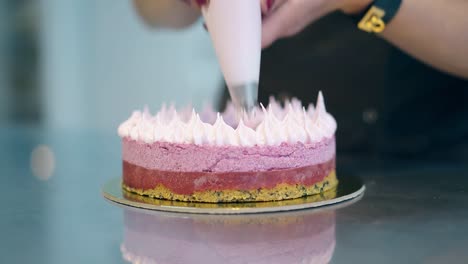 confectioner-decorates-three-layer-round-cake-with-cream