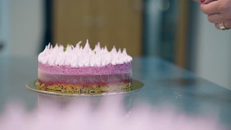close-view-girl-finishes-to-decorate-delicious-pink-cake