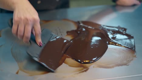 confectioner-makes-chocolate-glaze-using-pastry-scraper