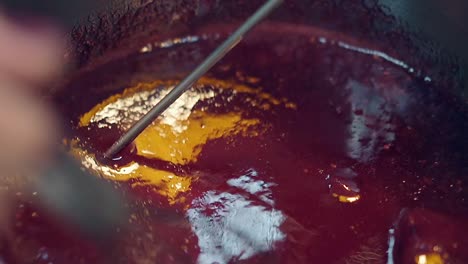confectioner-prepares-berry-caramel-in-metal-saucepan