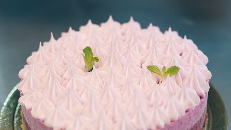 woman-puts-mint-leaves-to-decorate-pink-biscuit-cake