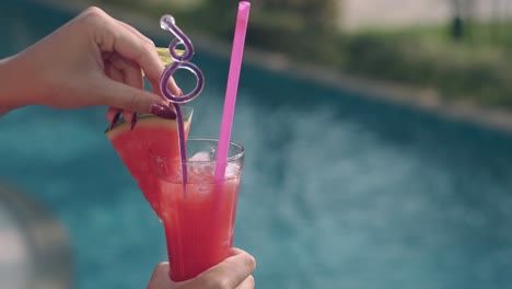 girl-holds-juicy-watermelon-cocktail-with-colorful-straws