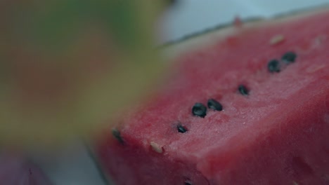 Makro-Saftige-Wassermelone-Mit-Schwarzen-Samen-Auf-Weißer-Oberfläche