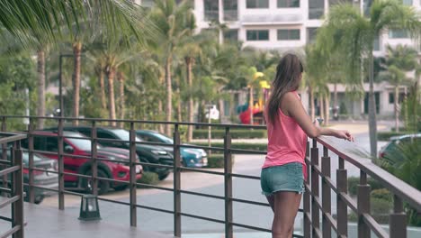 young-tourist-in-trendy-shorts-and-pink-top-observes-palms