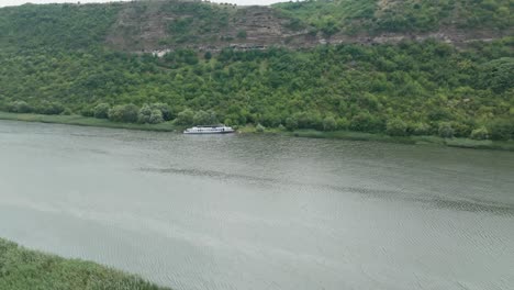 parked-ship-on-the-bank-of-the-river-which-is-located-between-two-high-hills-completely-green