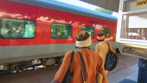 Rückaufnahme-Von-Hinduistischen-Priestern,-Die-Einen-Personenzug-Beobachten,-Der-Den-Bahnhof-Gwalior-In-Zentralindien-Verlässt