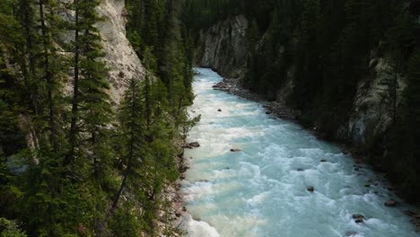 Cinematic-aerial-view-of-river-flowing-between-towering-cliffs,-British-Columbia