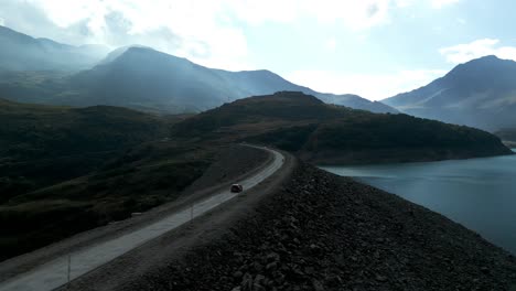 Aerial-View-Of-Car-Driving-Along-Mont-Cenis-Dam