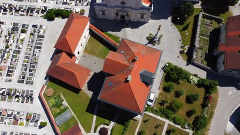 Aerial-top-down-shot-of-cathedral-with-graveyards-on-cemetery-in-Menges,-Slovenia-during-summer