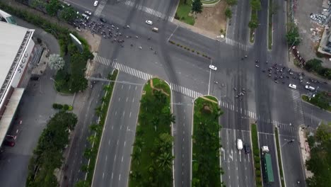 Top-down-aerial-drone,-crowded-intersection-filling-with-motorbikes-in-vietnam