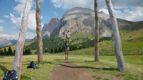 Hikers-enjoy-giant-swing-at-Williamshüttein-in-scenic-landscape-of-Seiser-Alm,-Italy