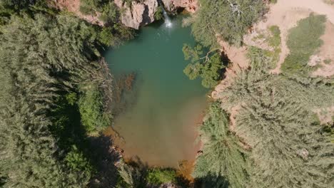 Drone-top-down-view-rising,-cascata-do-pego-do-inferno-hidden-waterfall-swimming-hole,-portugal