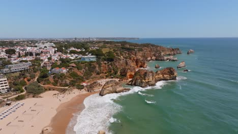 Static-aerial-establishing-shot-of-praia-dos-tres-Irmaos-and-Portimao-coastal-town,-portugal
