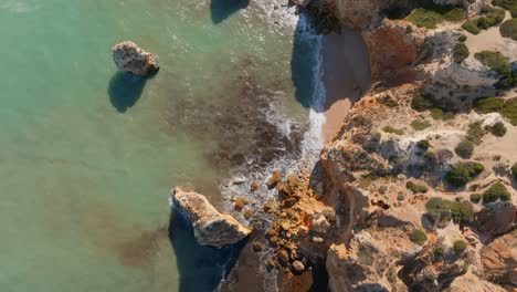 Top-down-trucking-aerial-pan-on-scenic-rocky-algarve-coastline,-portugal