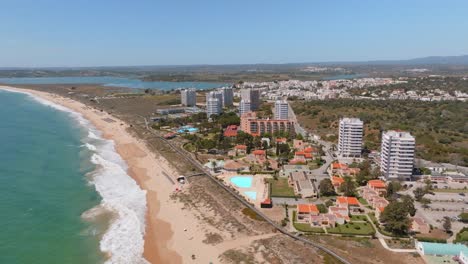 Stunning-coastline-of-Portimao,-luxury-ocean-view-hotel-high-rises,-aerial-pullback