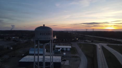 Silhouette-of-iconic-water-tower-during-sunset-in-South-Rockwood,-Michigan,-aerial-view