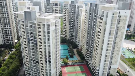 Modern-white-grey-apartment-buildings-around-pool-and-tennis-court-facilities,-down-town-urban