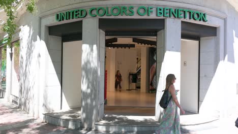 Pedestrians-walk-past-the-Italian-fashion-brand-United-Colors-of-Benetton-store-in-Spain