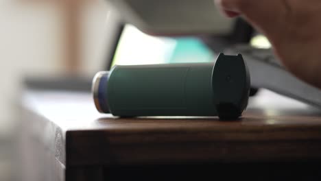 Hand-Grabbing-Asthma-Inhaler-from-Home-Office-Desk