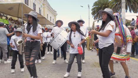 Experience-the-lively-atmosphere-as-a-group-of-girls-dressed-in-white-shirts-and-hats-play-the-saxophone-during-the-captivating-Chagra-Processional-Parade
