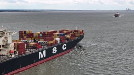 MSC-Madeleine-container-ship-sailing-up-river-Thames-Estuary-Aerial-drone-sailing-close-to-another-ship