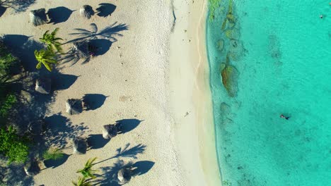 Daaibooi-Tropical-beach-bungalows-on-golden-sandy-shore,-clear-blue-water,-Curacao