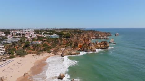 Sand-volleyball-courts-and-bungalows-on-scenic-algarve-portugal-beach,-aerial