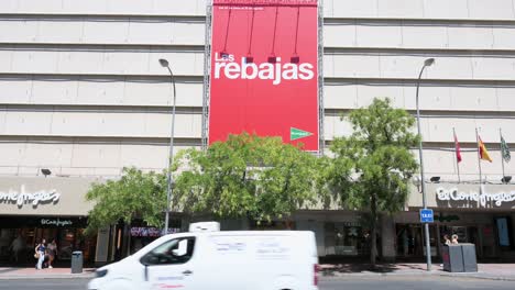 A-street-billboard-announcing-the-start-of-the-Summer-Sale-season-as-pedestrians-walk-past-it-in-Spain