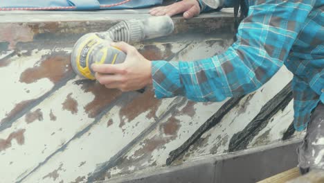 Using-an-orbital-sander-to-fair-the-hull-of-a-wooden-boat